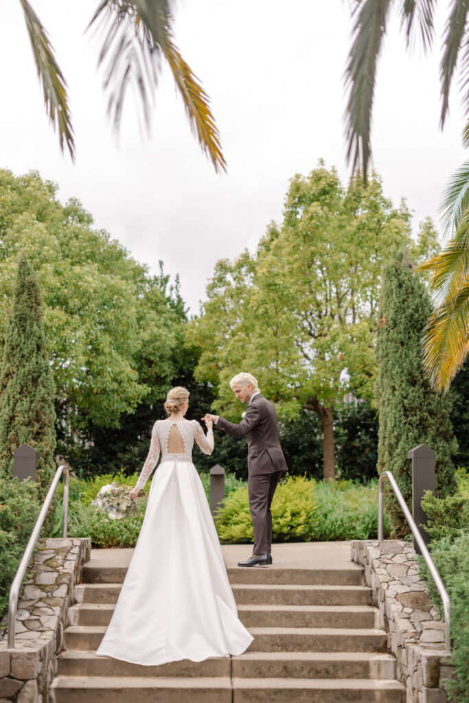 Bride and groom walking together during wedding portraits at Carneros Resort and Spa, surrounded by lush greenery in Napa Valley Wine Country.