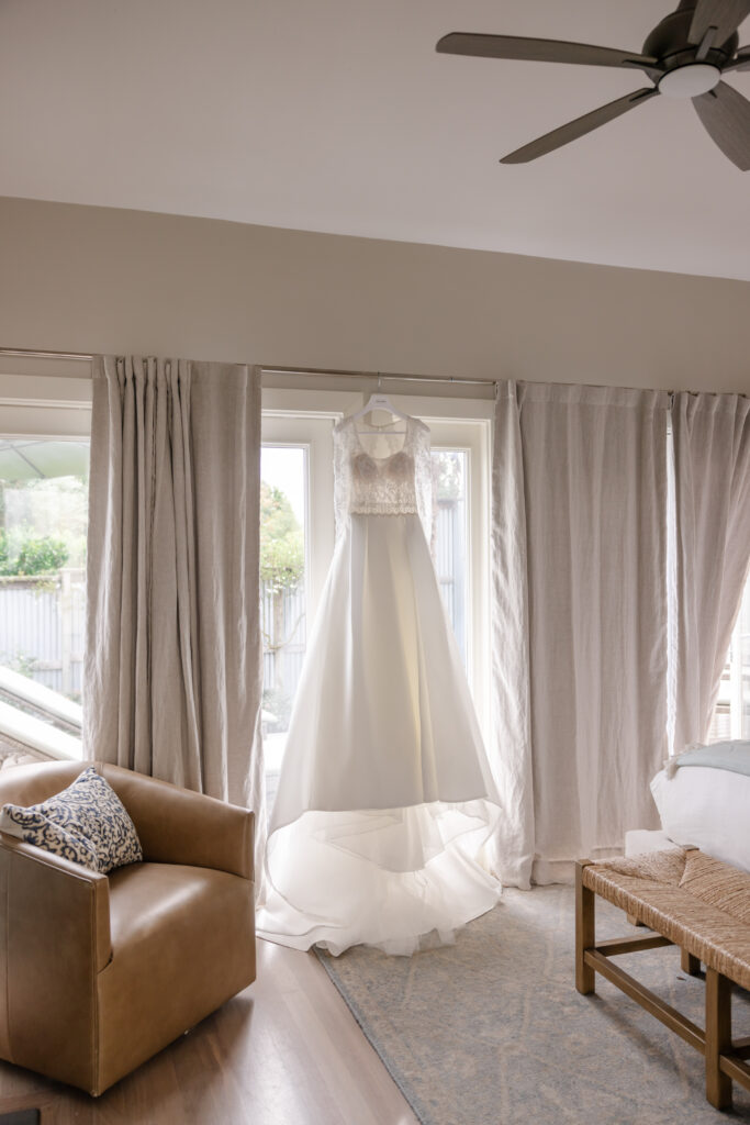 Wedding dress hanging in natural light while getting ready at Carneros Resort and Spa in Napa Valley, photographed at a Wine Country wedding venue.