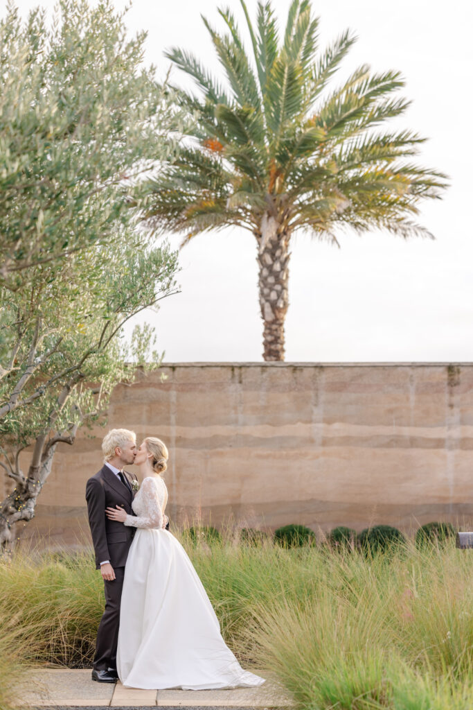 Bride and groom sharing a kiss during wedding portraits at Carneros Resort and Spa, photographed outdoors in Napa Valley at a Wine Country wedding venue.