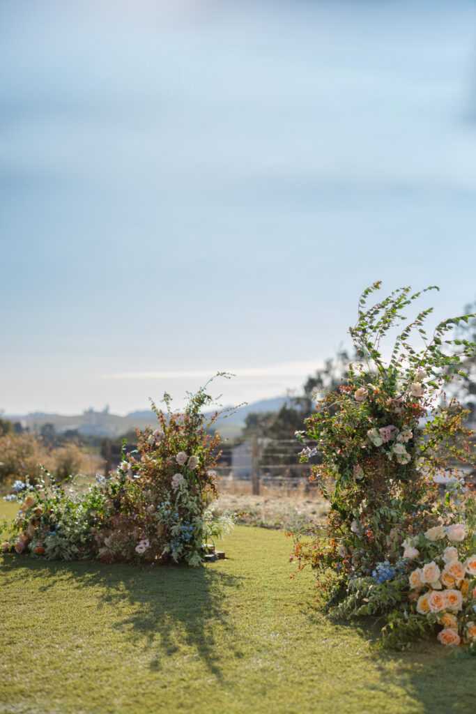 Floral ceremony arrangements set at the Hilltop Lawn at Carneros Resort and Spa, overlooking rolling vineyards in Napa Valley Wine Country.