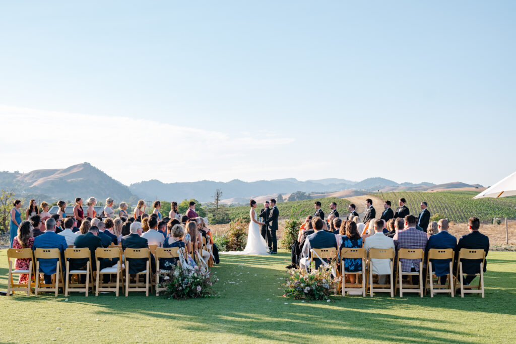 Outdoor wedding ceremony at the Hilltop Lawn at Carneros Resort and Spa, overlooking rolling vineyards in Napa Valley Wine Country.