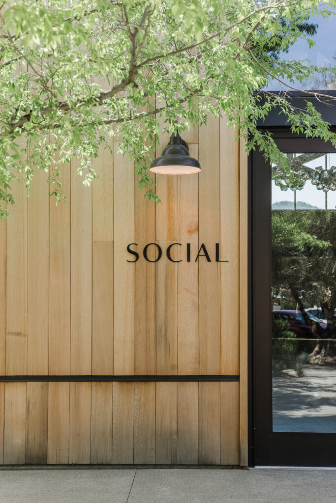 Exterior of The Social at Estate Yountville with wood-paneled entrance and modern signage