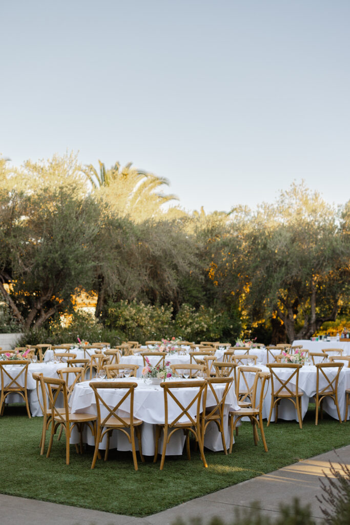 Outdoor reception setup at The Social at Estate Yountville with round tables beneath olive trees