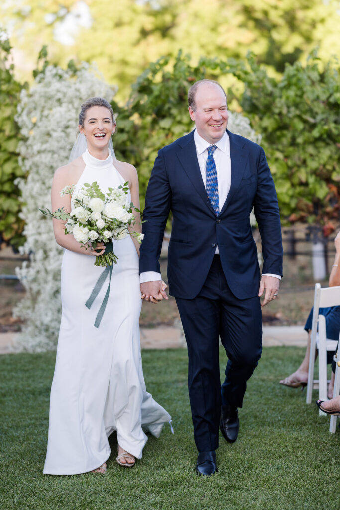 Bride and groom walking back up the aisle after their vineyard ceremony at Estate Yountville