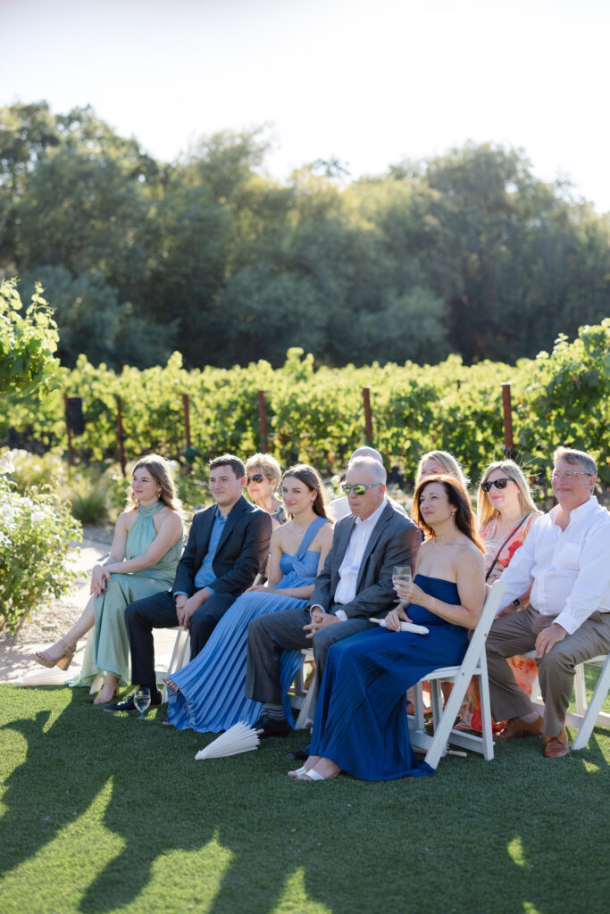 Wedding guests seated along the vineyard ceremony aisle at Estate Yountville in Napa Valley