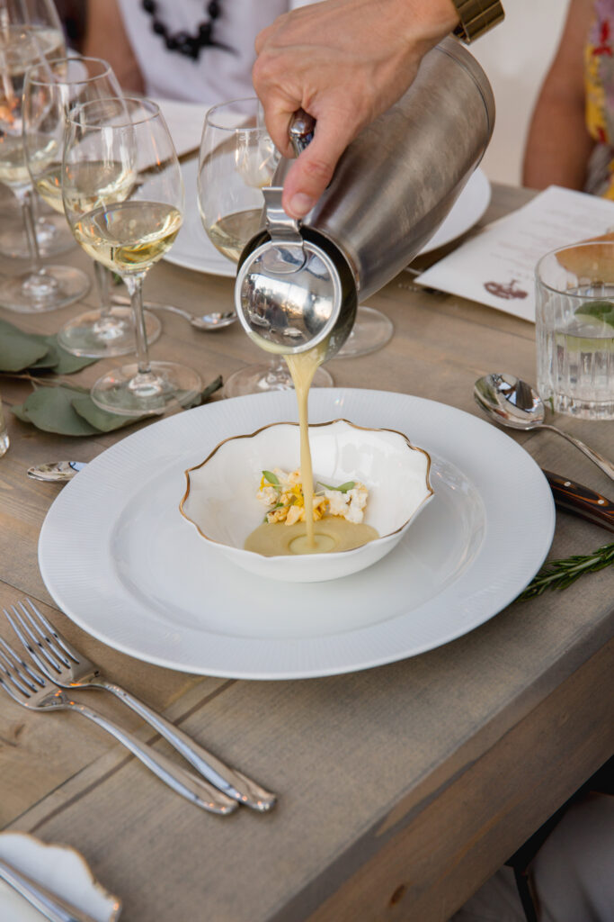 Server pouring plated course at outdoor wedding dinner at Montage Healdsburg