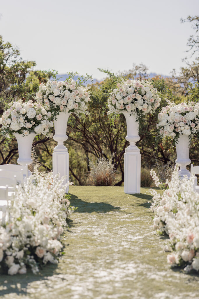 Outdoor ceremony aisle with floral arrangements and urns at Montage Healdsburg wedding venue