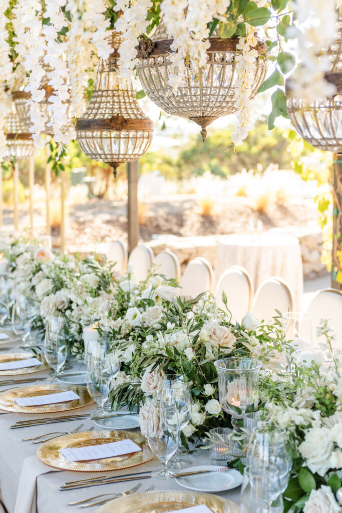 Elegant reception table with floral centerpiece and hanging chandeliers at Montage Healdsburg wedding venue