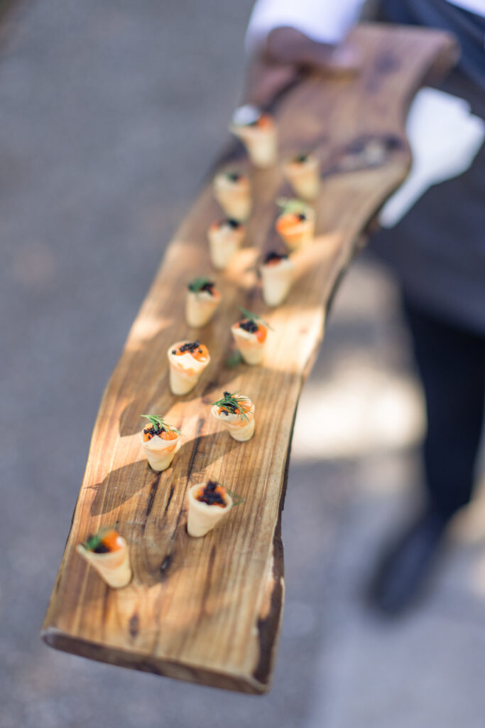 Elegantly tray passed appetizers by Paula LeDuc Catering served on a wooden board during cocktail hour at a Beaulieu Gardens wedding in Rutherford, Napa Valley, photographed by Napa Valley wedding photographer Suzanne Karp
