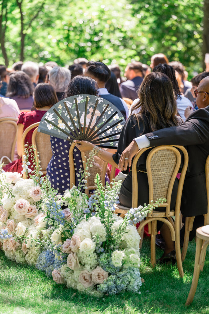 A close up of lush white garden roses, blue hydrangea, and blush blooms lining the ceremony aisle at Beaulieu Gardens in Rutherford during a Napa Valley wedding, photographed by Suzanne Karp Photography